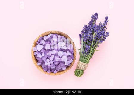 Fleurs de lavande et sel de bain dans un bol en bois sur fond rose. SPA, concept de soins du corps. Vue de dessus Banque D'Images