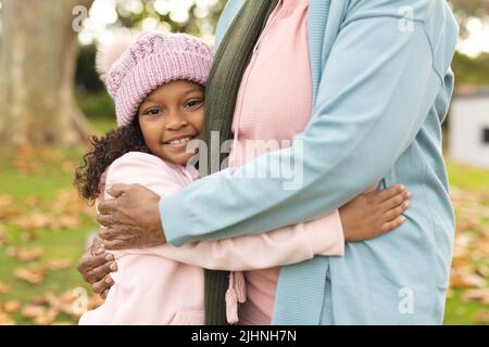 Image d'une grand-mère et d'une petite-fille afro-américaines qui s'embrassent dans le jardin Banque D'Images
