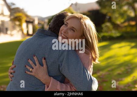 Image d'un couple caucasien âgé heureux qui s'embrasse dans le jardin Banque D'Images