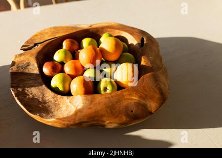 Image d'un bol en bois avec des pommes fraîchement cueillies et des oranges Banque D'Images