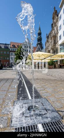 Zwickau, Allemagne. 19th juillet 2022. Bulles d'eau sur un trottoir à la place du marché de Zwickau. En particulier les jours chauds d'été comme le présent, la fonction d'eau fournit un peu de refroidissement et fait viventre la place dans le centre. Les centres-villes de Saxe se réchauffent également pendant les périodes de chaleur prolongées. Dans les villes densément construites, il n'y a pratiquement aucune brise. (À dpa: 'Des villes toujours plus chaudes - les municipalités recherchent des concepts pour la protection thermique') Credit: Hendrik Schmidt/dpa/Alamy Live News Banque D'Images