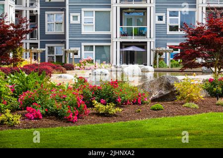 Jardin paysagé doté d'un élément d'eau dans un immeuble d'appartements à ossature de bois à Steveston, Colombie-Britannique, Canada Banque D'Images