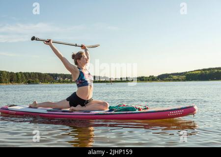 Sport femme yogini scorpion pose pratique yoga exercice sur le plan supérieur sur la mer en journée de détente, le yoga est la méditation et le sport sain concept.yoga sur Banque D'Images