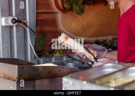 Mains d'un chef professionnel qui fabrique Shawarma dans un restaurant arabe Banque D'Images