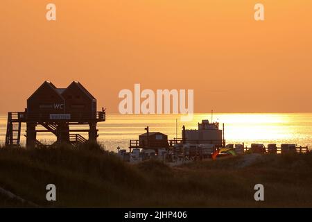 St. Peter Ording, Allemagne. 19th juillet 2022. Le soleil se couche le soir aux températures estivales sur la plage de Saint-Pierre-Ording. Crédit : Bodo Marks/dpa/Alay Live News Banque D'Images