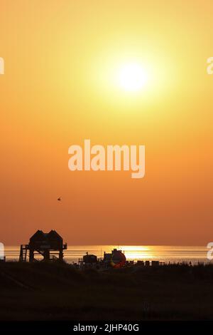 St. Peter Ording, Allemagne. 19th juillet 2022. Le soleil se couche le soir aux températures estivales sur la plage de Saint-Pierre-Ording. Crédit : Bodo Marks/dpa/Alay Live News Banque D'Images