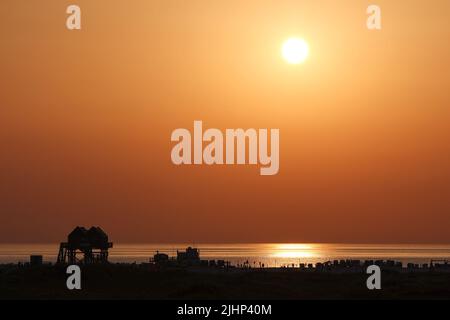 St. Peter Ording, Allemagne. 19th juillet 2022. Le soleil se couche le soir aux températures estivales sur la plage de Saint-Pierre-Ording. Crédit : Bodo Marks/dpa/Alay Live News Banque D'Images