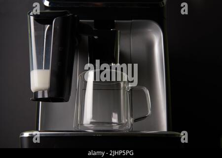Machine à café et gobelet en verre vide. Préparation professionnelle du café à la maison. Banque D'Images
