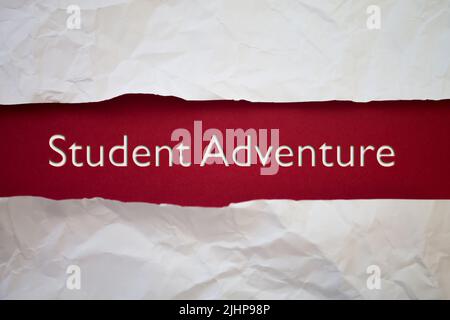 Texte de Student Adventure avec un livre blanc déchiré et froissé sur fond coloré. Banque D'Images