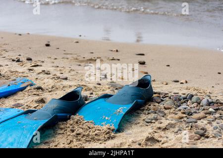 Gros plan sur les palmes bleus de plongée sur la plage. Concept d'équipement de plongée avec tuba. Banque D'Images