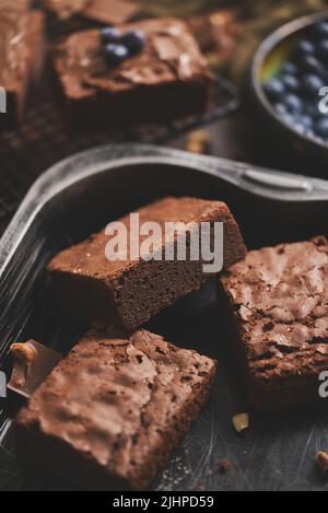 Composition de carrés de brownie au chocolat frais faits maison qui fondent le chocolat et les bleuets frais Banque D'Images