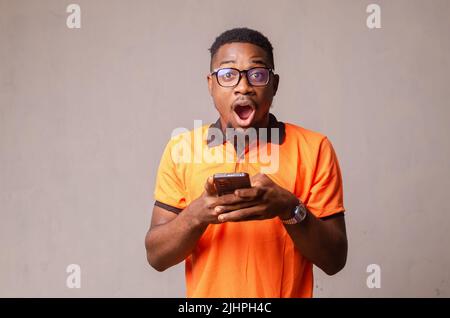 Photo de gai positif beau homme se réjouissant d'avoir reçu une longue notification dans les lunettes de vue criant trop joyeuse Banque D'Images