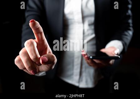 Femme d'affaires tenant un téléphone portable et pointant des idées importantes d'un seul doigt. Femme ayant un téléphone et affichant les mises à jour récentes à l'écran. Cadre Banque D'Images