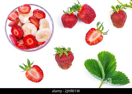 Fraises fraîches, une assiette avec des fraises en tranches et une banane, sur fond blanc gros plan Banque D'Images