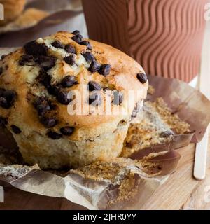 Un muffin aux pépites de chocolat dans un emballage en papier, prêt à manger. Banque D'Images