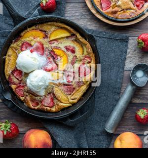 Vue de haut en bas d'une petite crêpe hollandaise à la pêche aux fraises recouverte de glace. Banque D'Images