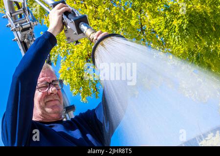 Schwerin, Allemagne. 20th juillet 2022. Frank Helms de la société Green et Clean Waters jeunes arbres dans une zone verte dans le centre-ville pour le compte de la ville. Avec son véhicule spécial et un réservoir contenant 2 000 litres d'eau de mer, il peut approvisionner jusqu'à 28 arbres avec l'eau vitale. Credit: Jens Büttner/dpa/Alay Live News Banque D'Images