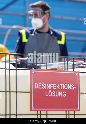 Nordhorn, Allemagne. 20th juillet 2022. Un employé de l'Agence fédérale allemande de secours technique (THW) se trouve dans un réservoir de solution désinfectante. Les véhicules sont nettoyés dans une installation de décontamination s'ils se trouvent dans une ferme située dans une zone de surveillance. À la suite de l'épidémie de peste porcine africaine dans une ferme du sud de l'Emsland, les comtés touchés prennent des mesures supplémentaires pour lutter contre la maladie animale. Un centre conjoint de logistique sur les maladies animales a commencé ses opérations dans les comtés de Grafschaft Bentheim et d'Emsland, à Nordhorn. Credit: Friso Gentsch/dpa/Alay Live News Banque D'Images