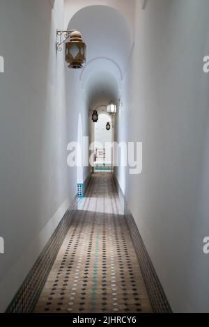 Couloir blanc étroit avec plancher carré sur une ancienne maison à Marrakech, Maroc Banque D'Images