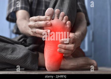 Sensation de picotement et de brûlure au pied d'un vieil homme asiatique avec diabète. Douleur au pied. Problèmes de neuropathie sensorielle. Problèmes de nerfs des pieds. Fasciite plantaire Banque D'Images