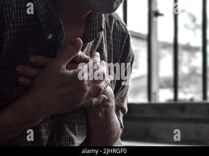 Image de silhouette partielle de l'homme asiatique aîné souffrant de douleurs thoraciques centrales. La douleur thoracique peut être causée par une crise cardiaque, un infarctus du myocarde ou une ischémie Banque D'Images