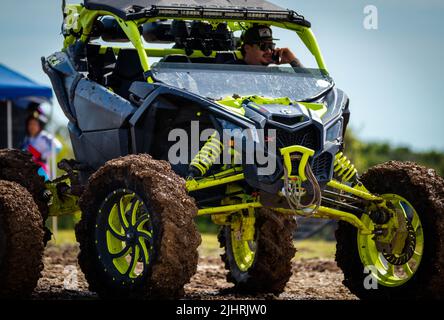 Un VTT avec des gens qui se conduisent et qui s'y conduisent sur un terrain sale et boueux au Rock Fest en 2020 Banque D'Images