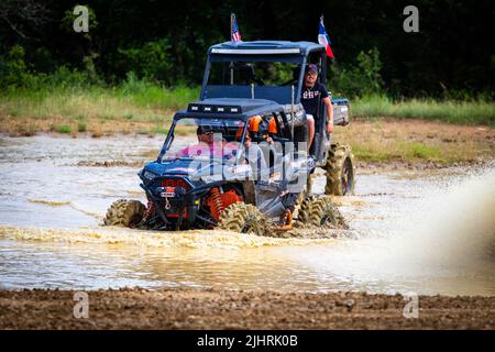 Un VTT avec des gens qui se conduisent et qui s'y conduisent sur un terrain sale et boueux au Rock Fest en 2020 Banque D'Images