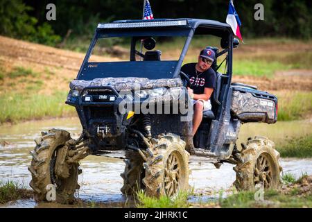 Un VTT avec des gens qui se conduisent et qui s'y conduisent sur un terrain sale et boueux au Rock Fest en 2020 Banque D'Images