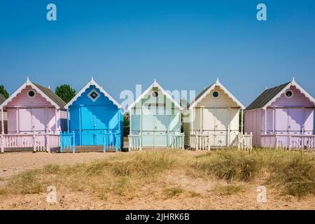 Vacances d'été traditionnelles au Royaume-Uni, vue en été d'une cabane de plage colorée sous un ciel bleu clair, West Mersea, Essex, Angleterre, Royaume-Uni Banque D'Images