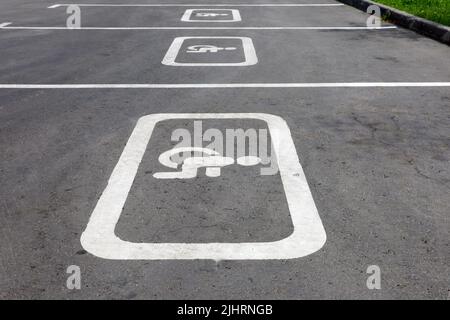 Panneaux de signalisation pour les parkings handicapés dans la rue. Place de parking pour handicapés, signe de fauteuil roulant peint sur l'asphalte Banque D'Images