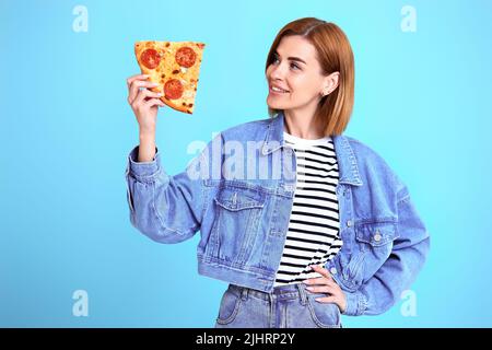 jeune femme avec tranche de pizza sur fond jaune. Banque D'Images