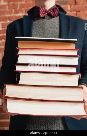 Homme méconnaissable tenant une pile de livres Banque D'Images