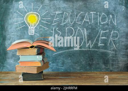 livres et tableau noir avec dessin d'une ampoule et slogan l'éducation est le pouvoir, l'apprentissage, la connaissance, le concept de retour à l'école Banque D'Images
