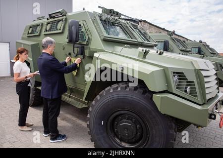 Le cinquième président de l'Ukraine, Petro Porochenko et son épouse Marina Porochenko, s'en tient à l'emblème de la Fondation Porochenko et d'autres organisations bénévoles du côté d'une voiture blindée. Les véhicules blindés achetés par la Fondation Porochenko avec des volontaires sont déjà près de la frontière ukrainienne et seront bientôt à l'avant. Les 11 nouveaux véhicules blindés de la norme de l'OTAN sont à la frontière polonaise et c'est la première fois que de nouveaux véhicules blindés de combat sont vendus à des volontaires et à des bienfaiteurs, a déclaré M. Porochenko. Banque D'Images