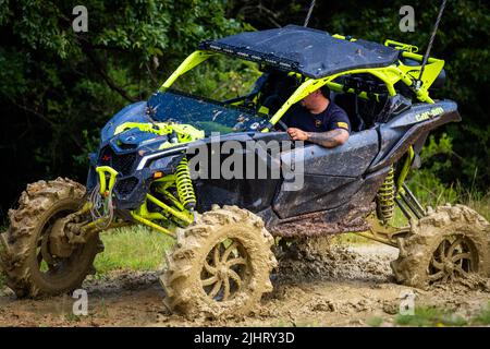 Un VTT avec des gens qui se conduisent et qui s'y conduisent sur un terrain sale et boueux au Rock Fest en 2020 Banque D'Images