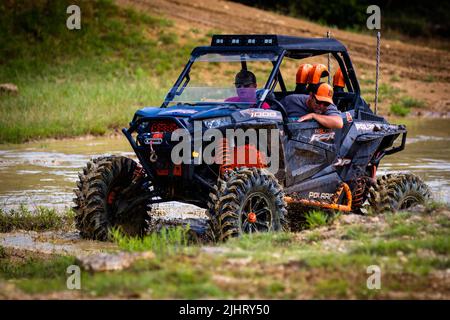 Un VTT avec des gens qui se conduisent et qui s'y conduisent sur un terrain sale et boueux au Rock Fest en 2020 Banque D'Images