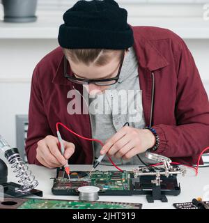 Le réparateur sourie le processeur en atelier Banque D'Images