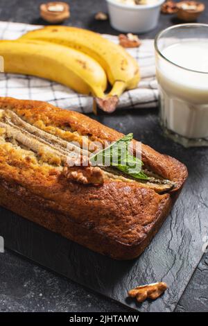 Pain à la banane ou gâteau sur table en pierre noire. Délicieux dessert maison, en-cas savoureux ou petit déjeuner du matin. Banque D'Images