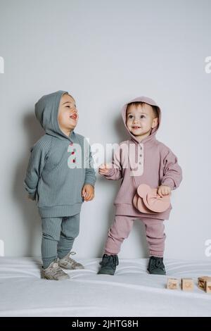 Mode bébé. Vêtements unisexes pour bébés. Ensemble en coton pour deux jeunes filles ou garçons Banque D'Images