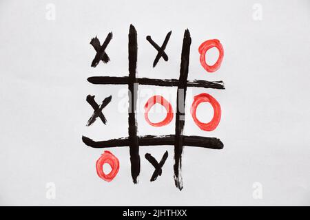 le jeu de tic-tac-toe est tiré sur des peintures sur papier blanc, jouer et se reposer, le jeu des enfants de noughts et de croix Banque D'Images