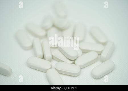 Tas de pilules blanches médicales sur fond blanc Banque D'Images
