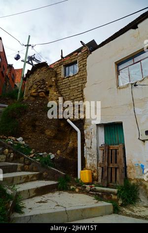 La Paz, Bolivie: Une maison en adobe / mudbrick mal construite avec un système de drainage dangereux causant la filtration de l'eau et l'érosion des sols des fondations dans le district de Tembladerani / Cotahuma. De nombreux quartiers de la Paz à flanc de colline ont été construits dans des zones instables sans permis ou contrôles de construction appropriés. La subsidence et l'érosion causant des glissements de terrain et des maisons à s'effondrer sont courantes, en particulier pendant la saison des pluies. Banque D'Images