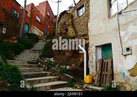 La Paz, Bolivie: Une maison en adobe / mudbrick mal construite avec un système de drainage dangereux causant la filtration de l'eau et l'érosion des sols des fondations dans le district de Tembladerani / Cotahuma. De nombreux quartiers de la Paz à flanc de colline ont été construits dans des zones instables sans permis ou contrôles de construction appropriés. La subsidence et l'érosion causant des glissements de terrain et des maisons à s'effondrer sont courantes, en particulier pendant la saison des pluies. Banque D'Images