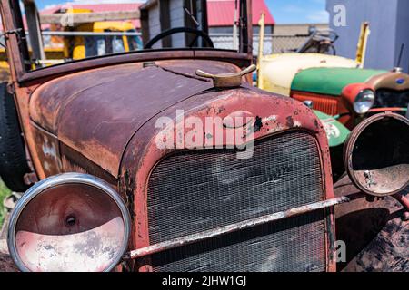 Vieille voiture rouillée abandonnée dans un jardin de junkyard Banque D'Images