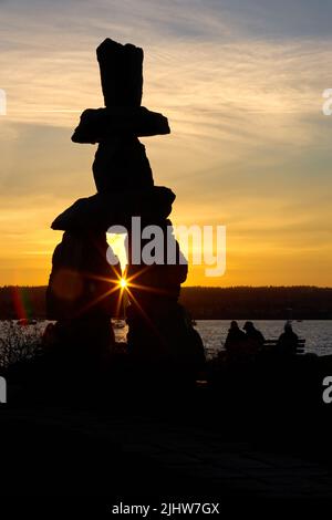 English Bay Vancouver Inukshuk coucher de soleil. Les gens dehors en admirant un coucher de soleil sur English Bay, Vancouver. Banque D'Images