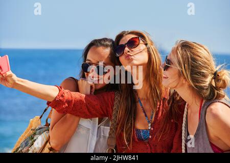 Frappez votre meilleure posture. Trois meilleurs amis prennent des selfies ensemble à l'aide d'un smartphone. Banque D'Images