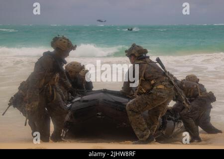 ZONE D'ENTRAÎNEMENT DU CORPS MARIN SOUFFLETS, Hawaï (18 juillet 2022) Marines des États-Unis avec 3rd Bataillon de reconnaissance, 3rd Division marine et soldats de l'armée australienne tirent un engin de raudage en caoutchouc de combat sur la plage pour l'entraînement helo-Cast pendant la Rim du Pacifique (RIMPAC) 2022, à la zone d'entraînement du corps marin Bellows, Hawaï, 18 juillet. Vingt-six nations, 38 navires, quatre sous-marins, plus de 170 avions et 25 000 membres du personnel participent au programme RIMPAC de 29 juin au 4 août dans les îles hawaïennes et dans le sud de la Californie. Le plus grand exercice maritime international au monde, RIMPAC fournit un u Banque D'Images