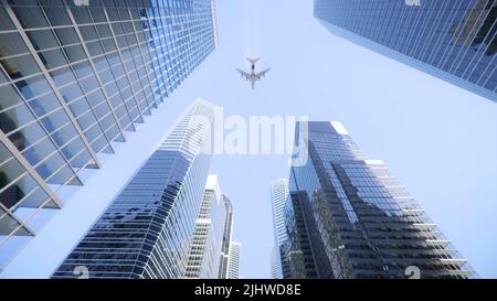 Photo en bas angle d'un avion volant au-dessus de gratte-ciel modernes dans le centre-ville Banque D'Images