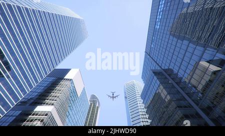 Photo sous angle d'un avion volant au-dessus de gratte-ciel modernes dans le centre-ville Banque D'Images