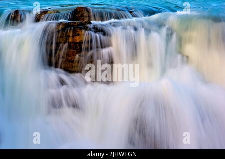 Un gros plan de l'eau de la rivière Athabasca, alimentée par un glacier, se précipitant au-dessus des chutes Athabasca dans une puissante ruée. Banque D'Images